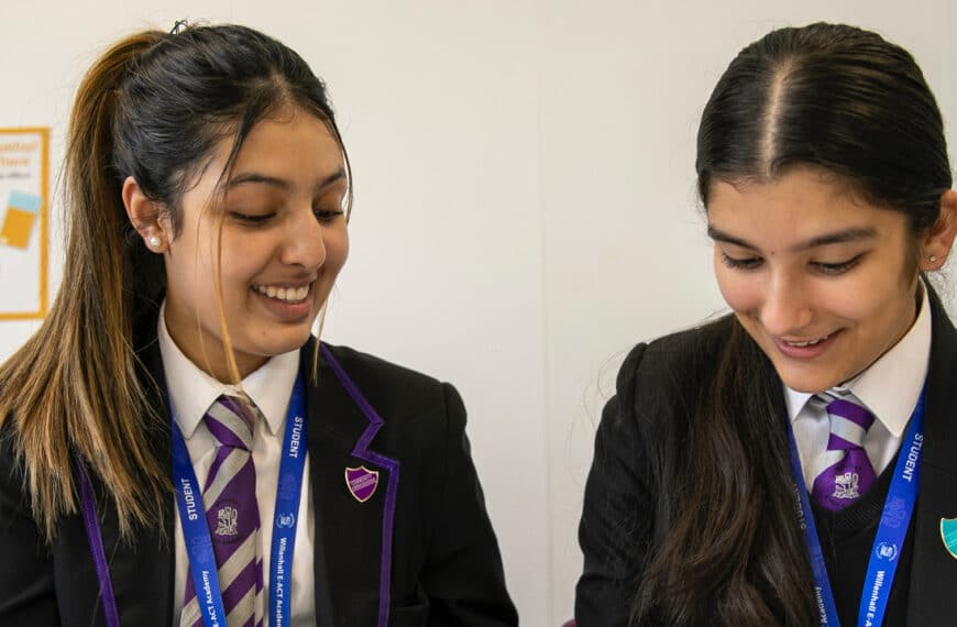 two schoolchildren look over books