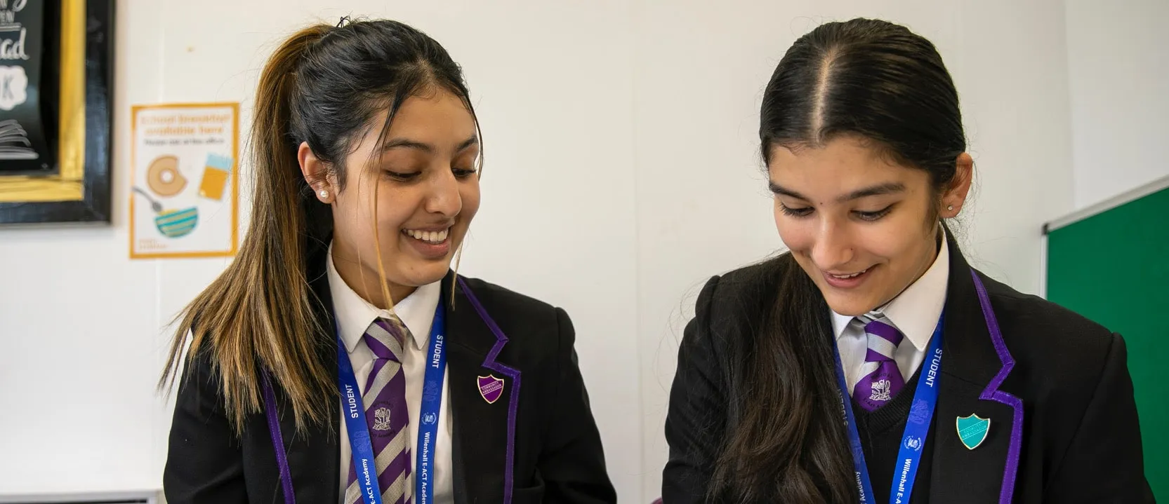 two schoolchildren look over books