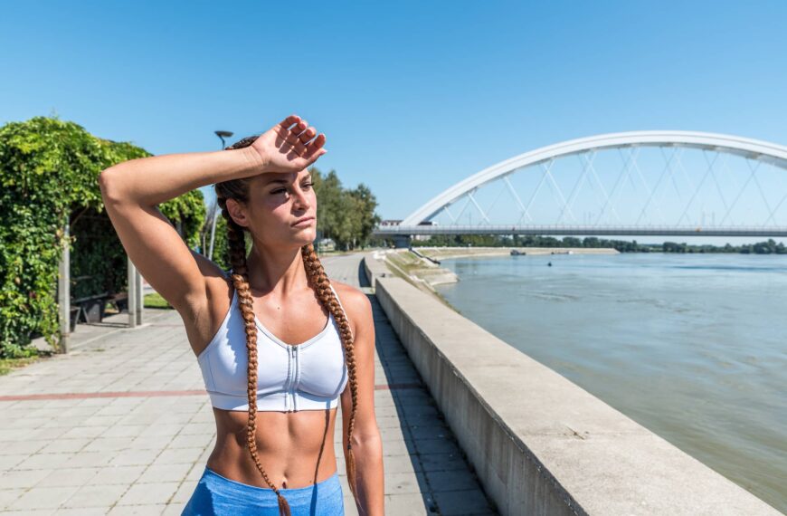 Fit strong muscular woman wiping sweat from her forehead after hard core outdoor cross workout training