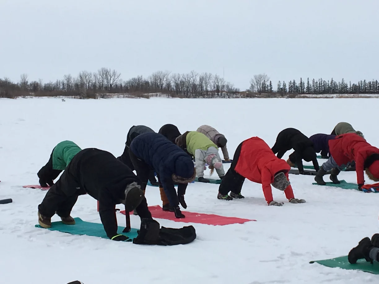 People practice yoga in the snow