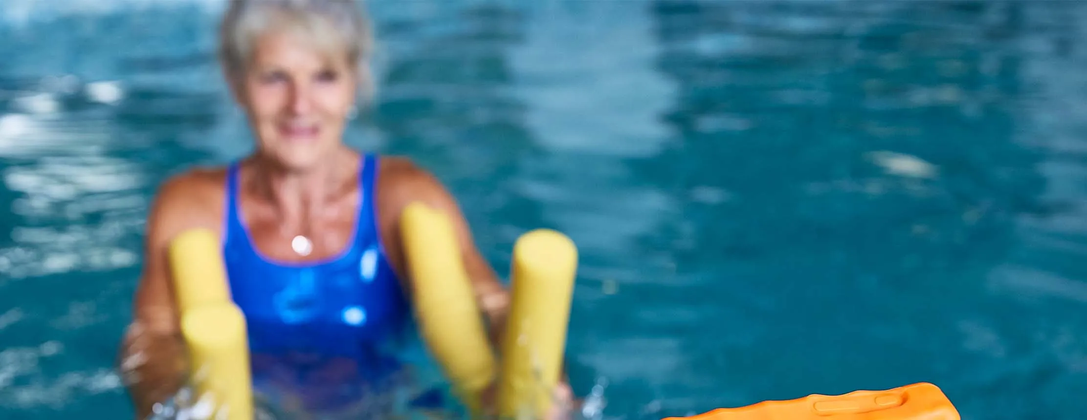 woman in swimming pool watches tablet