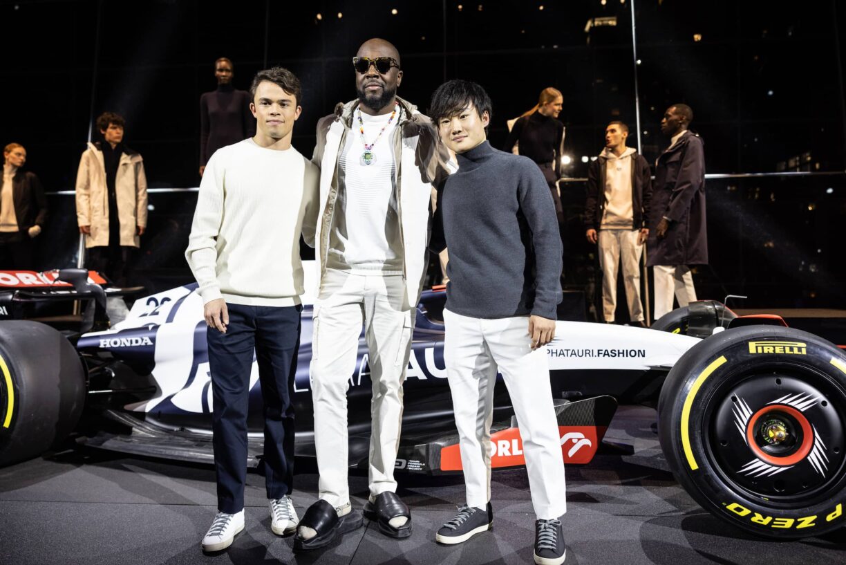 Scuderia AlphaTauri Formula One drivers Nyck De Vries and Yuki Tsunoda with Wyclef Jean in front of the 2023 car 