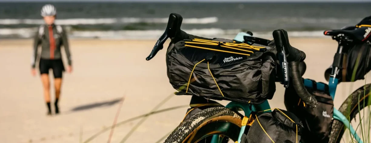 jack wolfskin cyclist with bike on beach