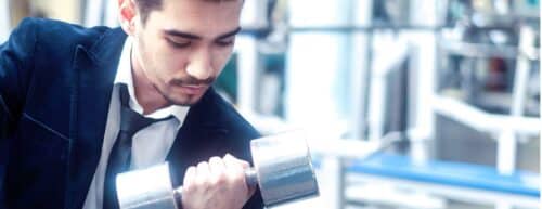 man in suit holding dumbbell