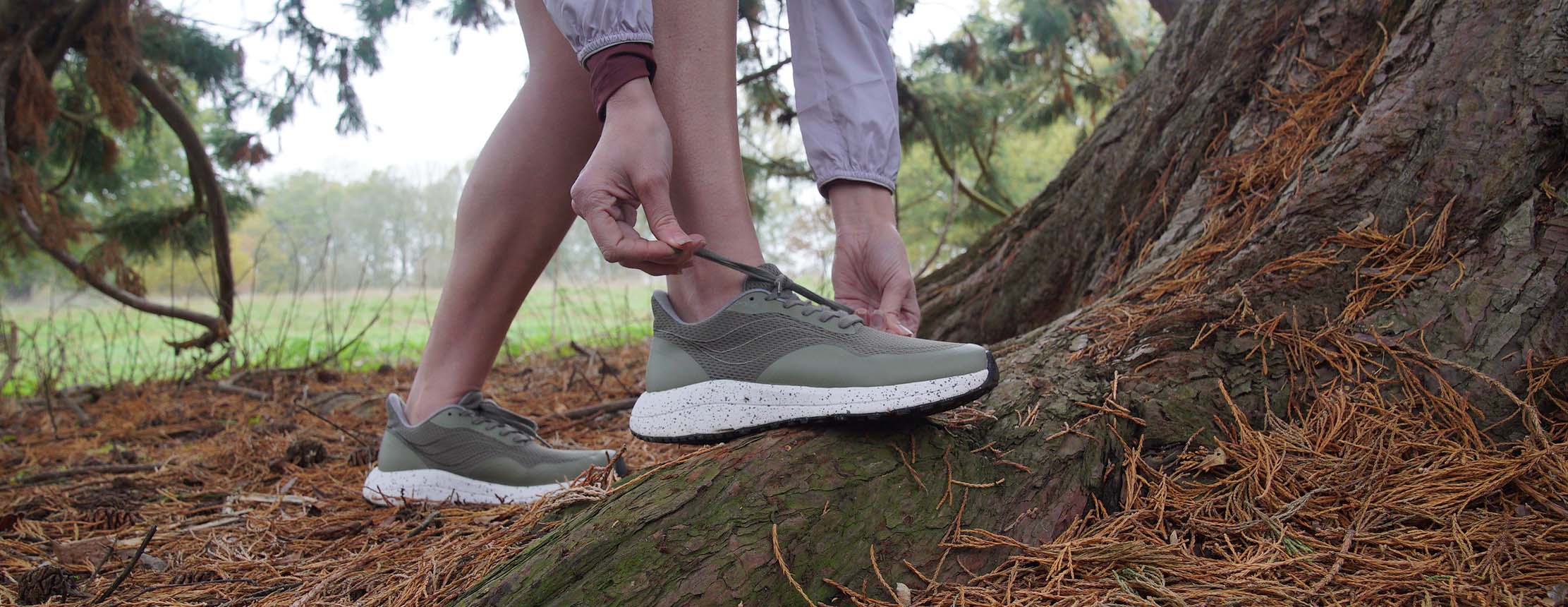 Runner ties laces by a tree