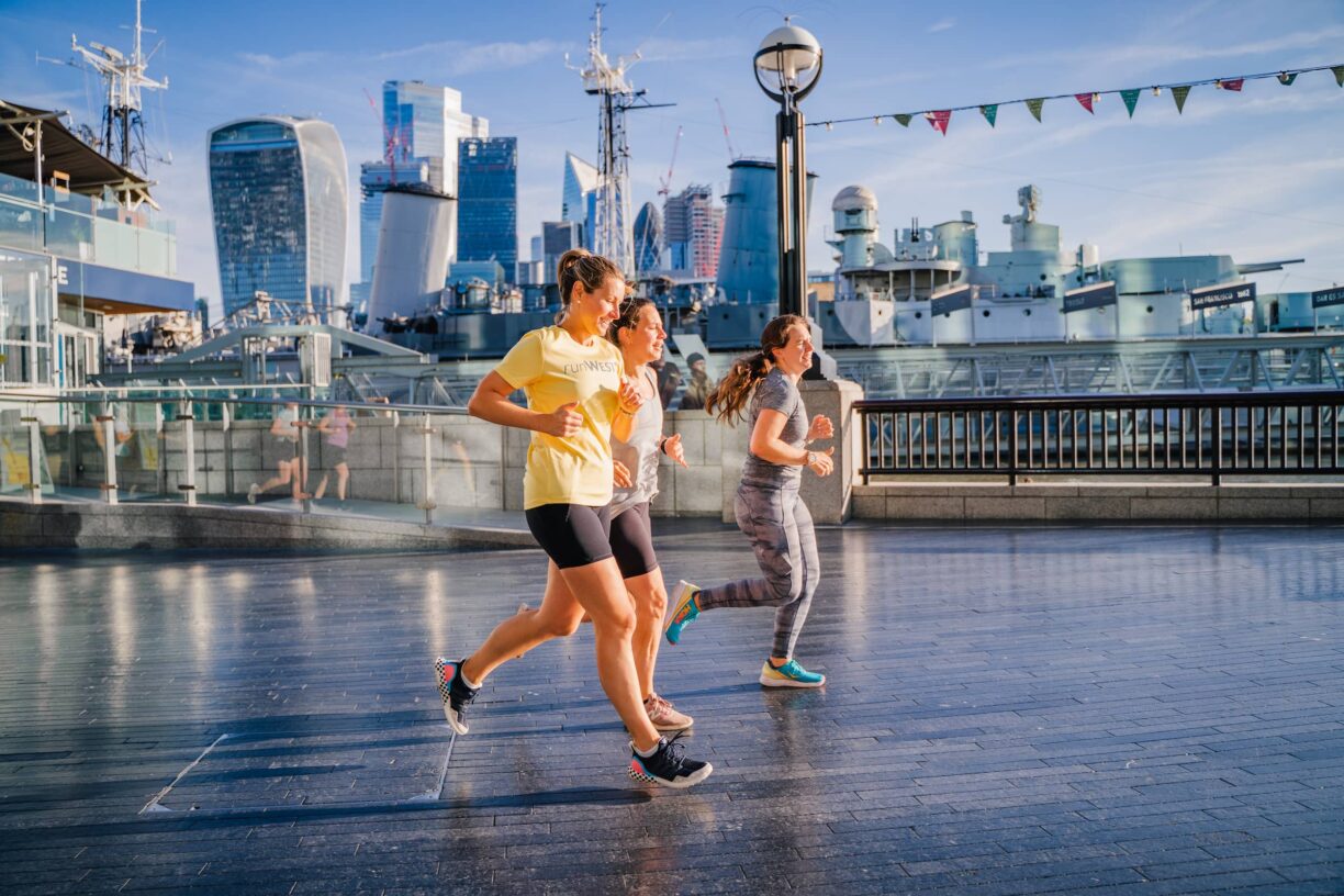 group of runners run past the tower of london