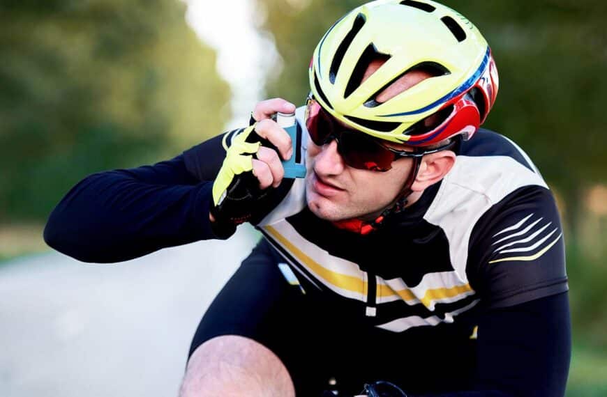 Cyclist using asthma inhaler while riding a bicycle