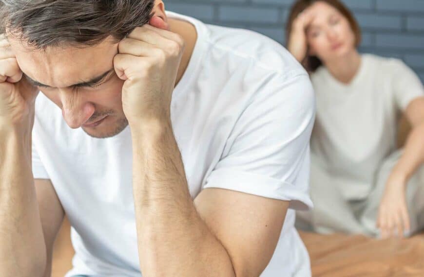 Frustrated and depressed man sitting on the edge of the bed