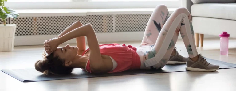 Woman in activewear lying on sports mat resting after training