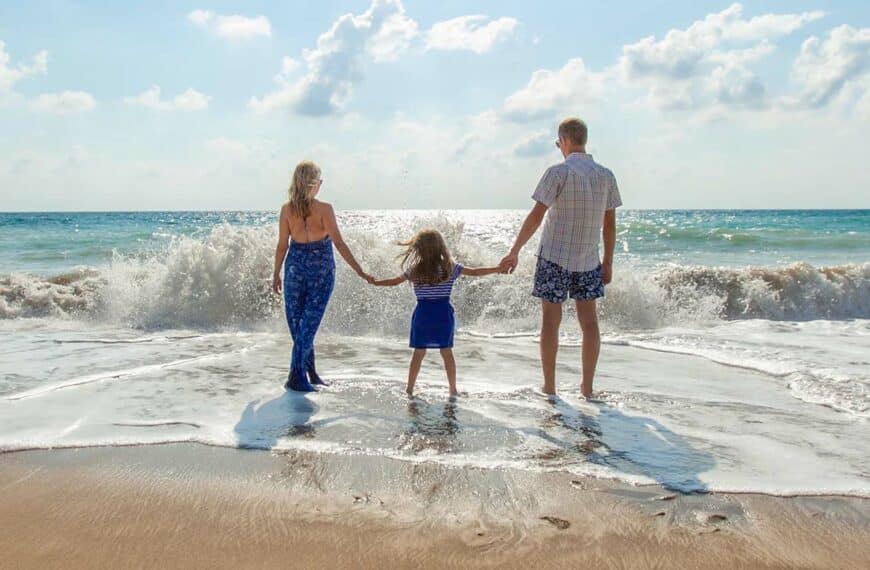 family hold hands on the beach