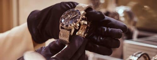 gloved hands hold expensive luxury watch
