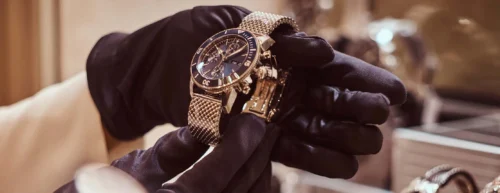gloved hands hold expensive luxury watch