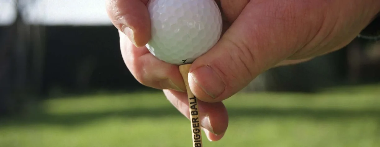golf ball on tee being placed into ground