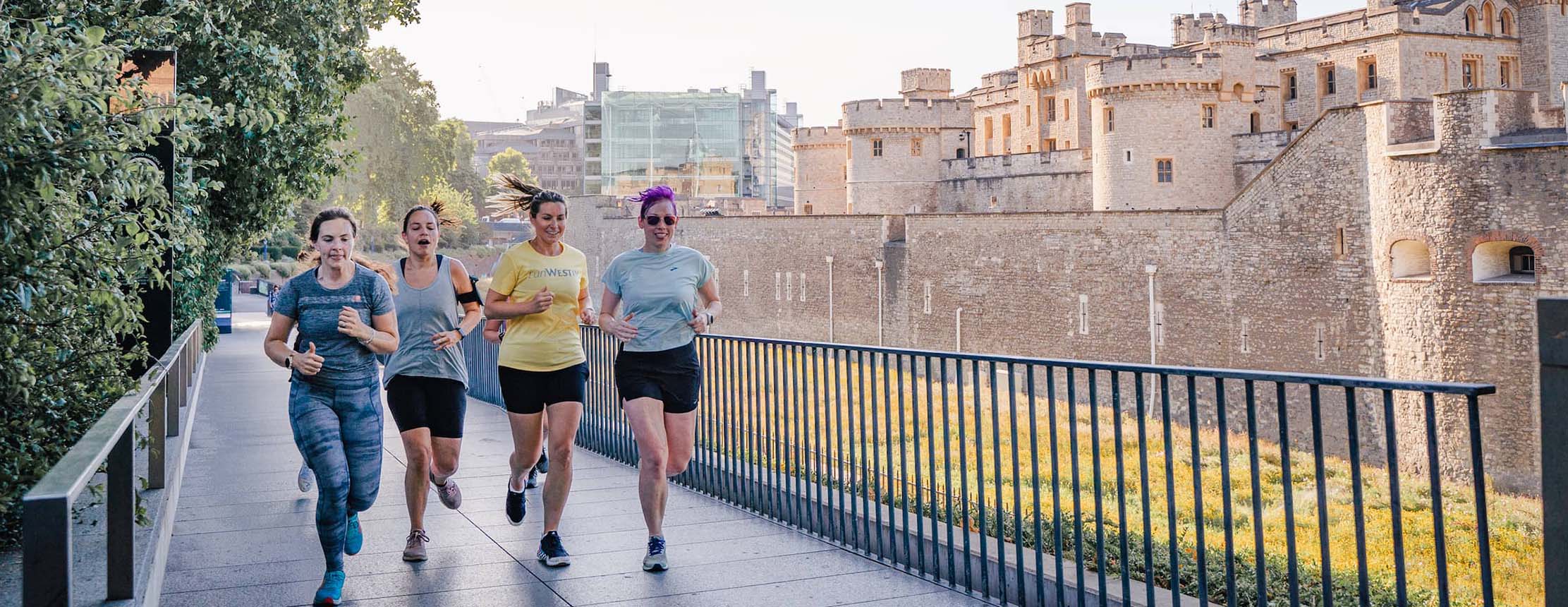 Group of runners run past the tower of london
