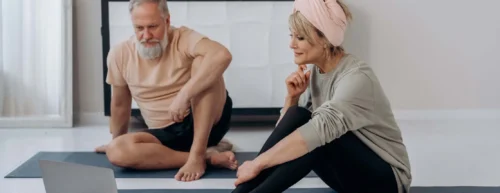 older couple sit looking at laptop