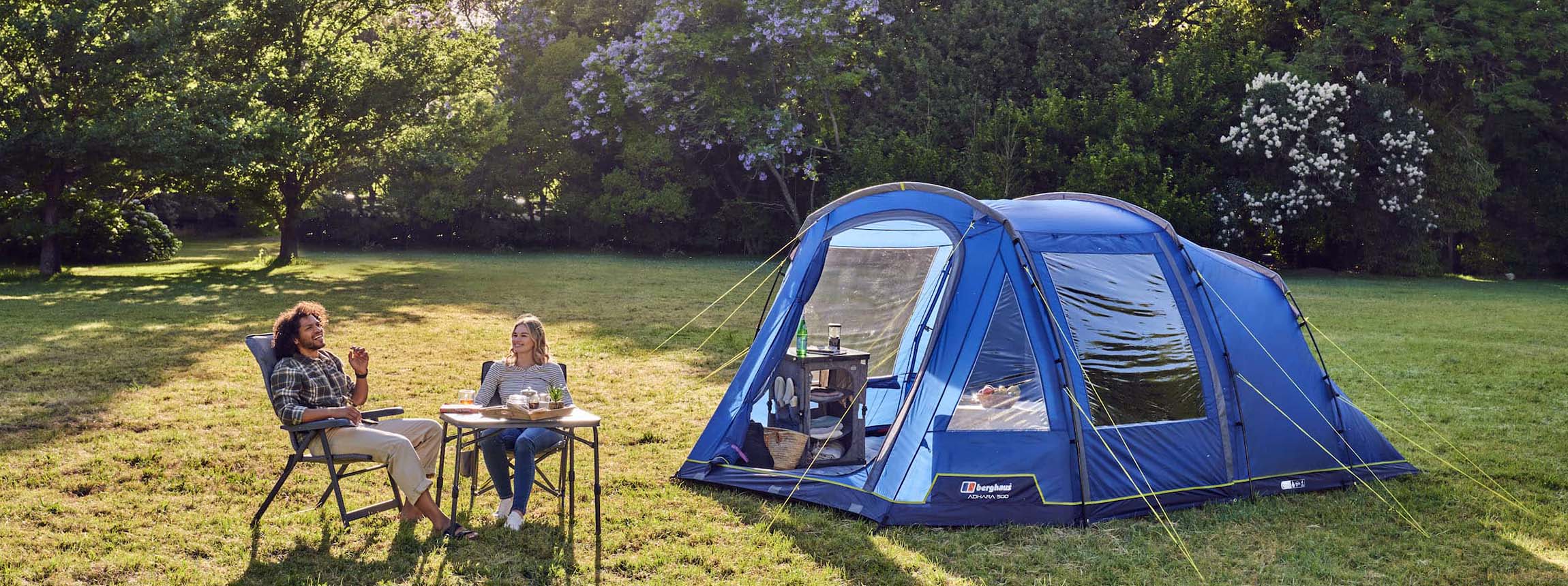 Couple sit outside a tent