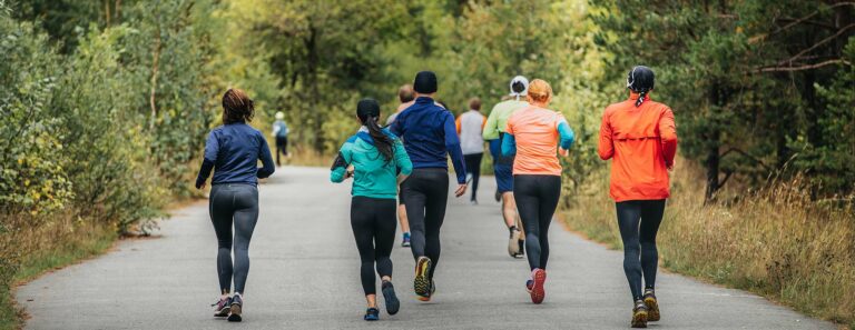 runners run along paved road