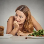 woman looks fearful at food