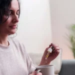 Woman taking cbd oil for anxiety treatment - Vitamins and supplements