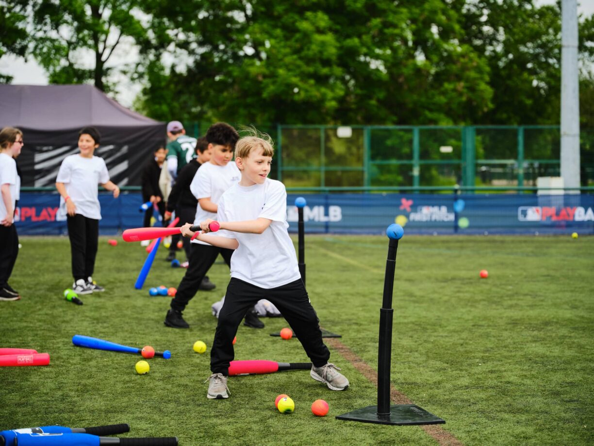 young baseball players hitting the ball