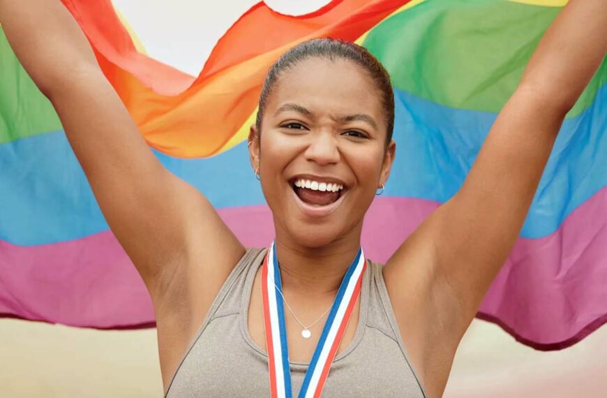 young athlete holds an LGBTQ+ flag