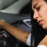 young woman rubbing her neck, feeling sore after long drive