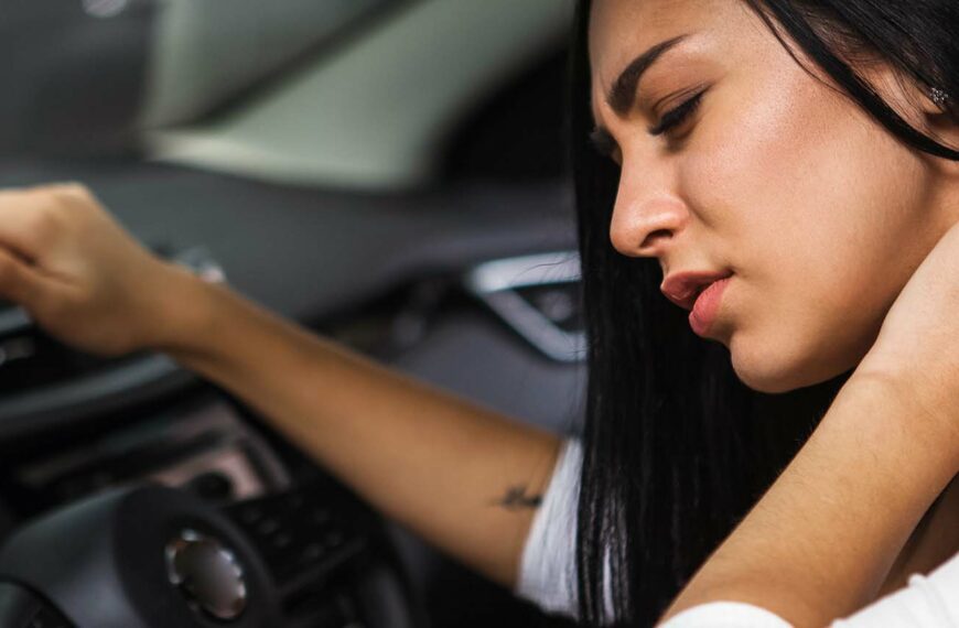 young woman rubbing her neck, feeling sore after long drive