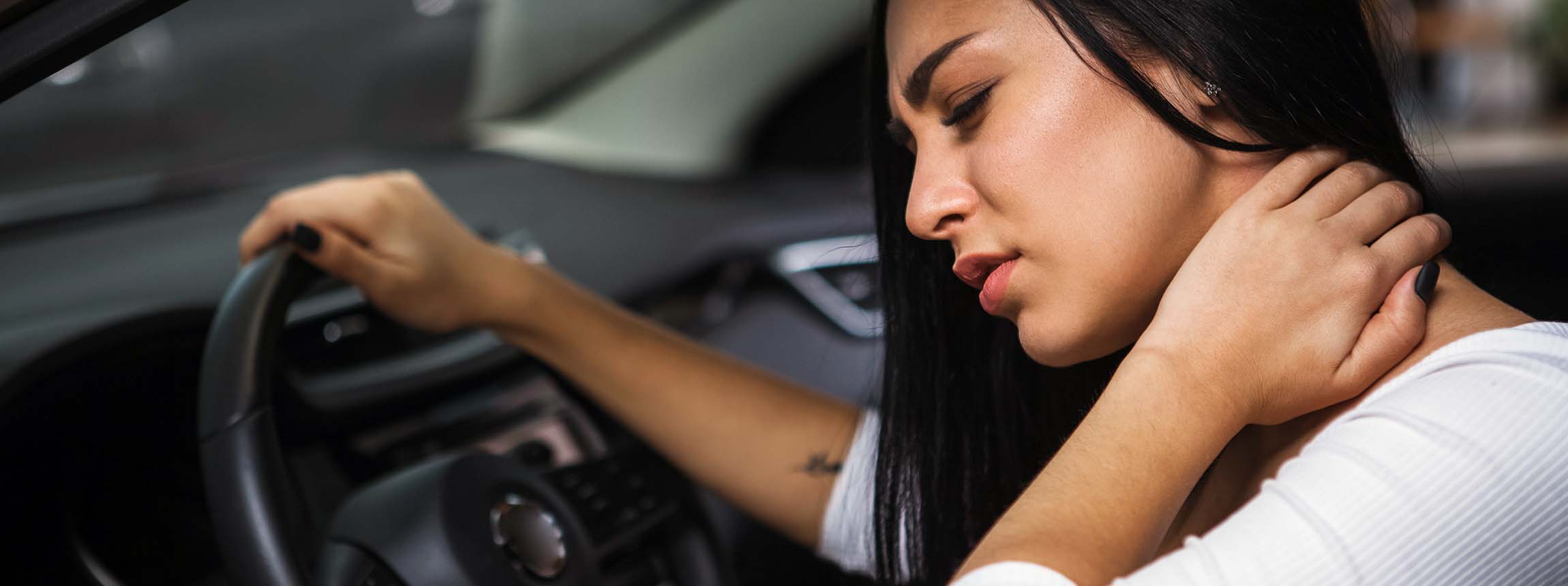 Young woman rubbing her neck, feeling sore after long drive