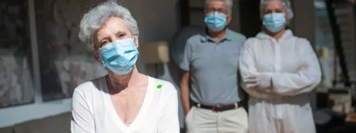 mature people stand wearing facemasks