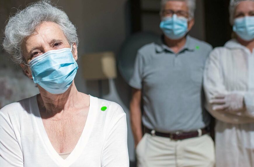 mature people stand wearing facemasks