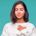 young woman holds hands lovingly to her chest
