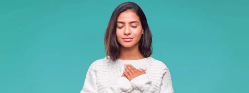 young woman holds hands lovingly to her chest