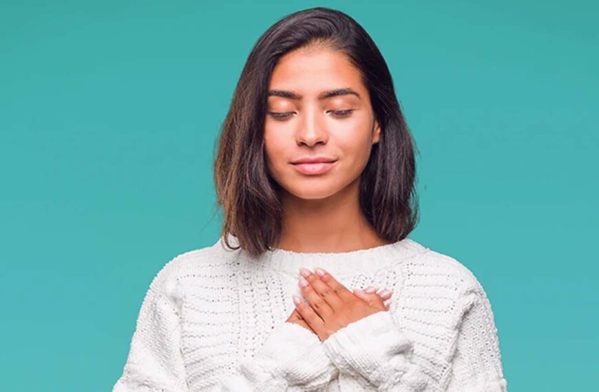 young woman holds hands lovingly to her chest