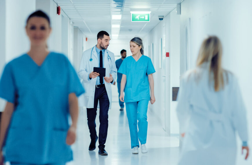 doctor talks to nurse in hospital corridor