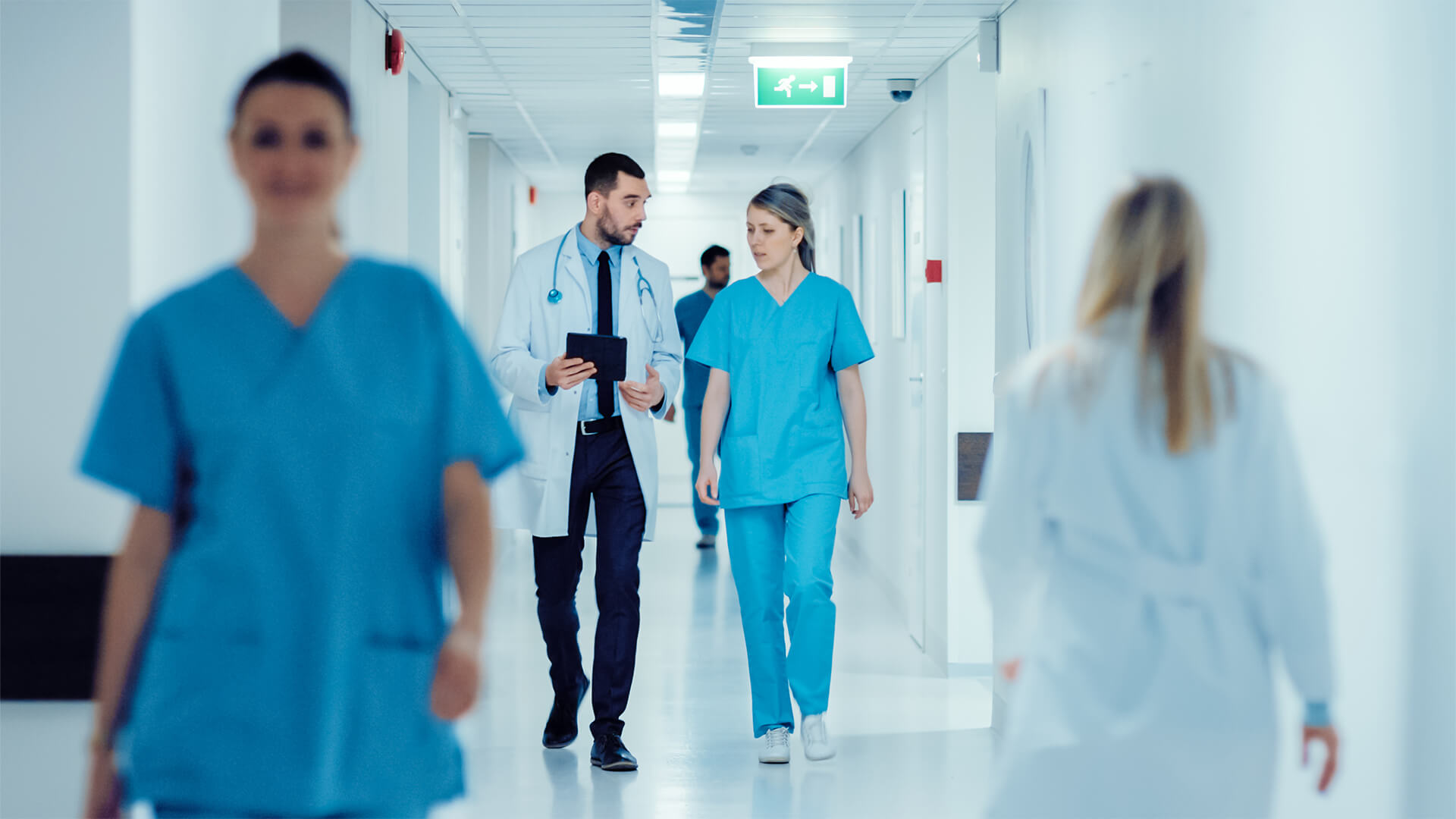 Doctor talks to nurse in hospital corridor