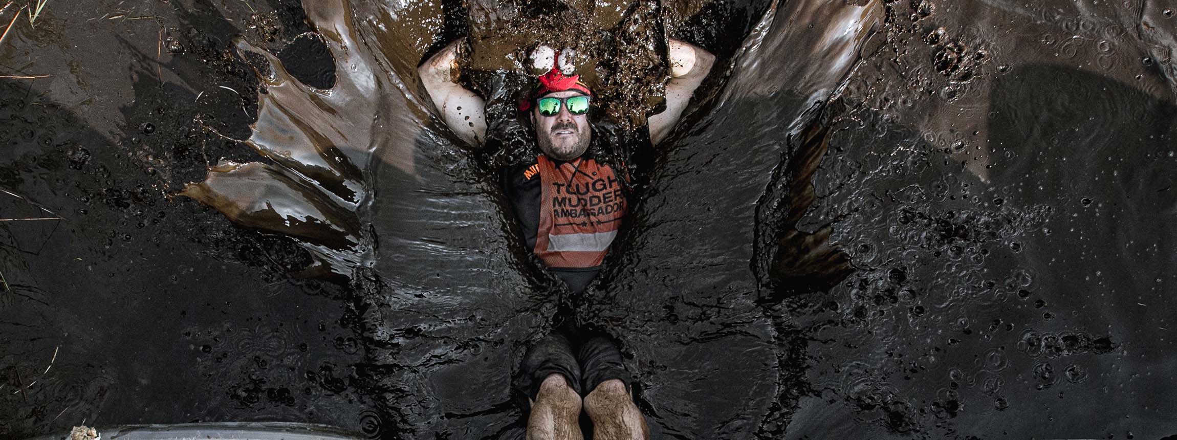 Tough mudder participant lays in mud
