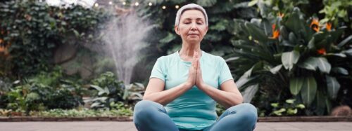 Senior woman sits in yoga position