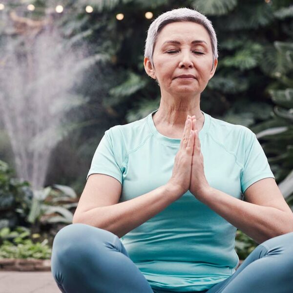 Senior woman sits in yoga position