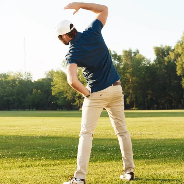 Young male golfer stretching muscles before starting the game