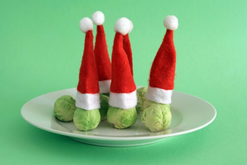 Brussel Sprouts Wearing Christmas Festive Hats. Christmas Vegetables Concept.
