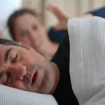 Woman suffers from her male partner snoring in bed