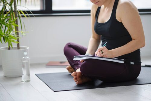 Yoga woman writing in her notebook