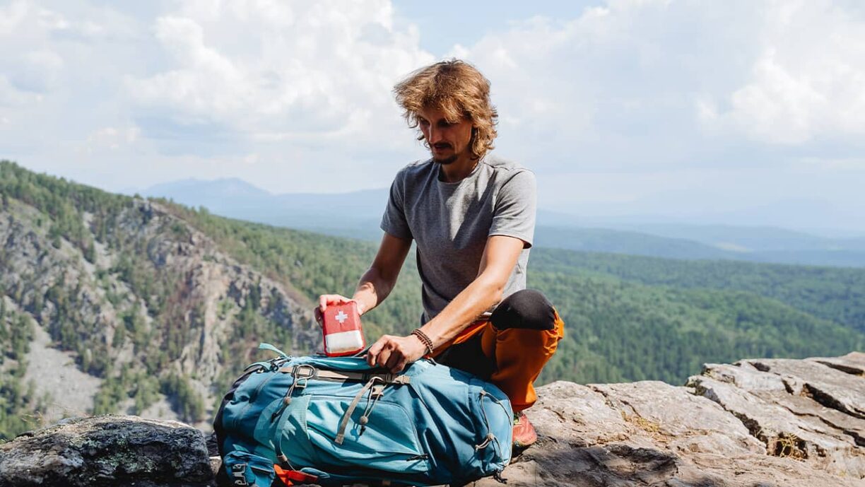 Hiker in mountains with first aid kit