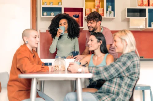 young people in kitchen relaxing and chatting together