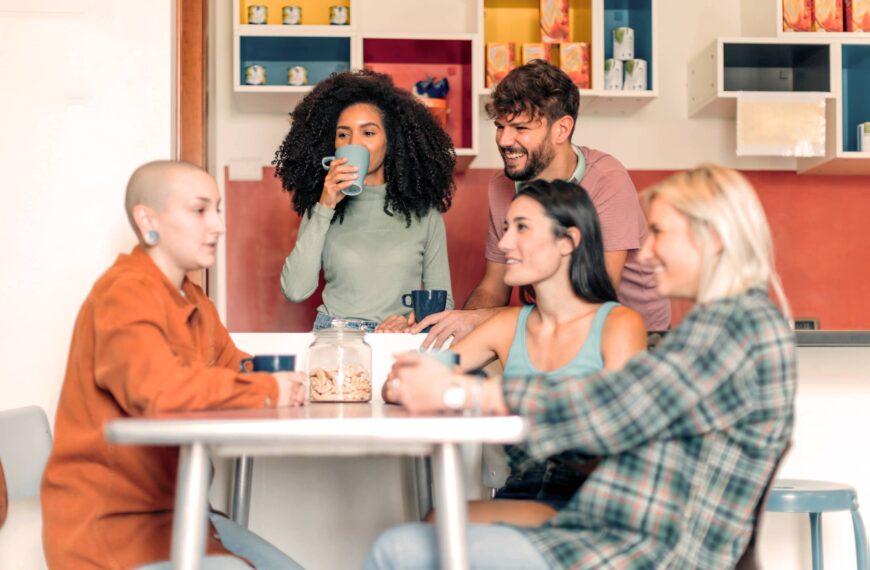 young people in kitchen relaxing and chatting together