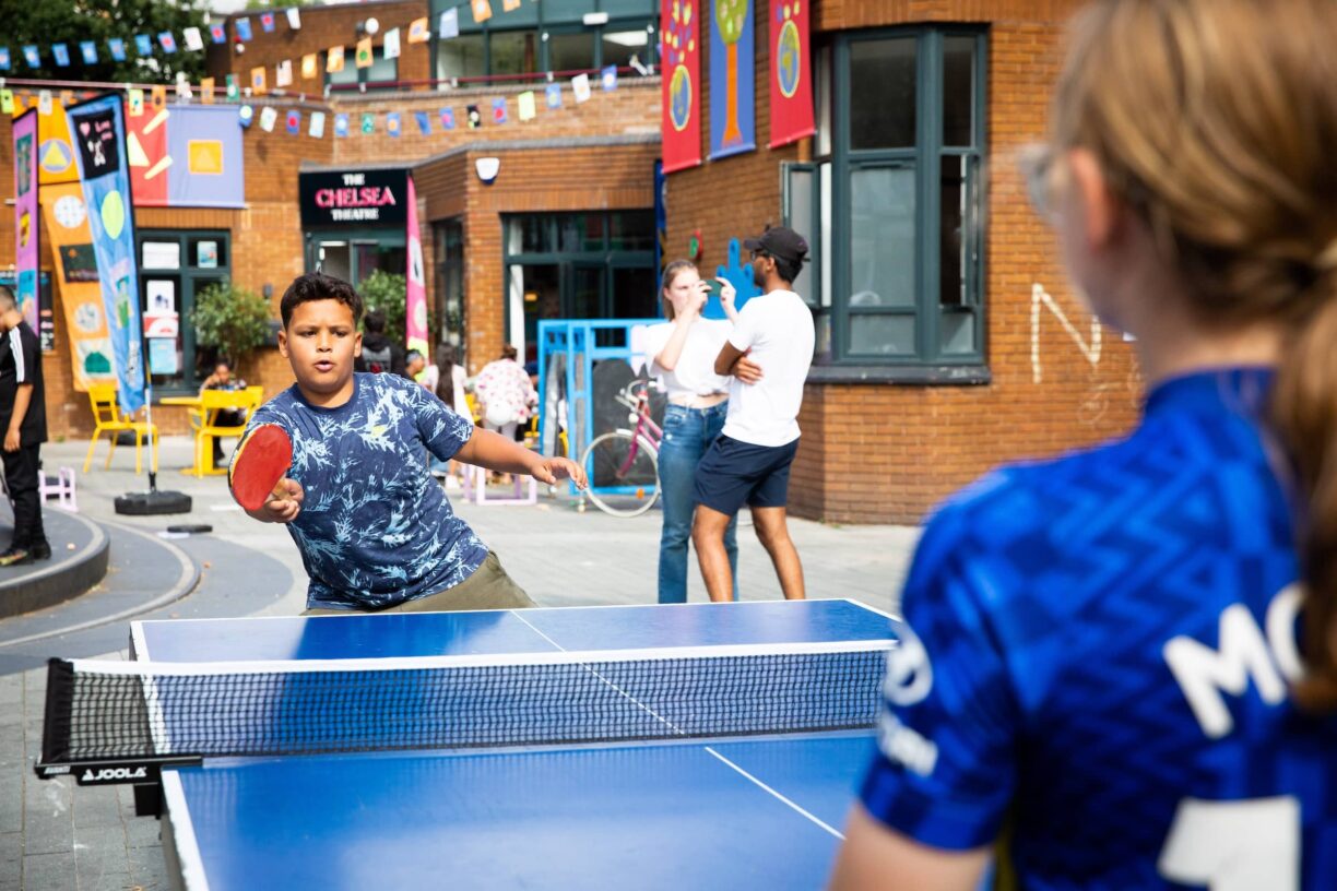 Children play table tennis outside
