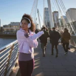 Fit looking woman stretches whilst on a bridge over the Thames