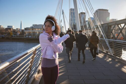 Fit looking woman stretches whilst on a bridge over the Thames