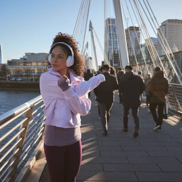Fit looking woman stretches whilst on a bridge over the Thames