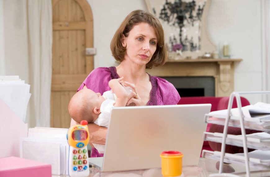 Mother and baby in home office with laptop